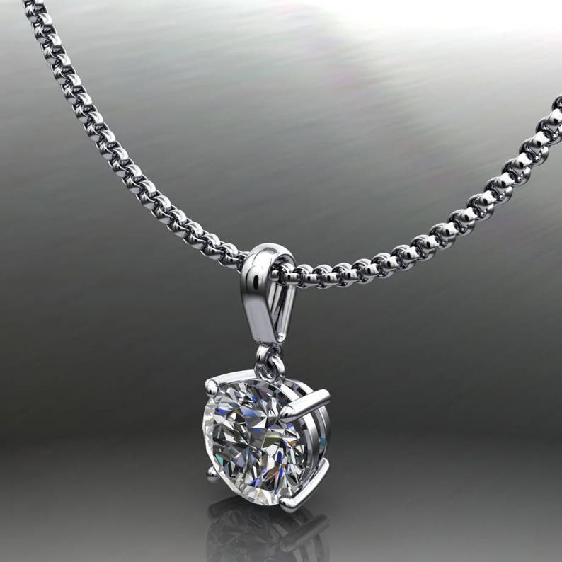 May include: A silver chain necklace with a round, clear diamond pendant.