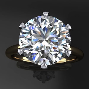 May include: A large, round, clear diamond ring set in a yellow gold band. The diamond has many facets and sparkles brightly.