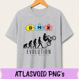 May include: A light gray t-shirt featuring a BMX-themed design. The design includes puzzle pieces spelling "BMX" above a silhouette depicting the evolution of man, culminating in a BMX rider performing a trick. The word "EVOLUTION" is printed below.