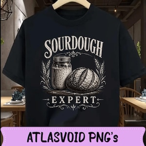 Peut inclure: T-shirt noir avec un graphisme de style vintage. Le motif présente les mots "SOURDOUGH EXPERT" au-dessus d'un pot de levain et d'un pain, encadrés d'épis de blé. Le design est en blanc.