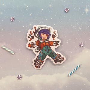 May include: A colorful sticker featuring a cartoon character wearing a white helmet and orange and green clothing. The character is in a dynamic pose with arms outstretched and legs spread wide. The sticker has a white background and is printed on a glossy surface.