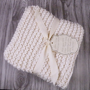 Pu&ograve; includere: Un canovaccio in cotone bianco lavorato a mano, legato con un nastro bianco e un'etichetta che recita "100% Cotone Tricotato a Mano Realizzato in 100% cotone. Lavare i colori separatamente in acqua tiepida. Asciugare in asciugatrice a bassa temperatura."
