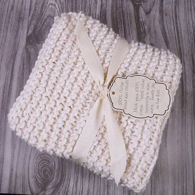 Pu&ograve; includere: Un canovaccio in cotone bianco lavorato a mano, legato con un nastro bianco e un'etichetta che recita "100% Cotone Tricotato a Mano Realizzato in 100% cotone. Lavare i colori separatamente in acqua tiepida. Asciugare in asciugatrice a bassa temperatura."