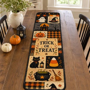 May include: A rectangular Halloween table runner featuring a patchwork design with illustrations of a ghost, witch hat, haunted house, pumpkin, black cat, candy corn, and cauldron. The center panel displays the text Trick or Treat in black.