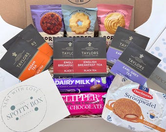 Può includere: Una confezione regalo contenente un assortimento di snack e bevande, tra cui bustine di tè Taylors of Harrogate nelle varietà Assam, English Breakfast ed Earl Grey, biscotti Border, una barretta di cioccolato Cadbury Dairy Milk, cioccolata calda Clipper e un wafer Daelmans.