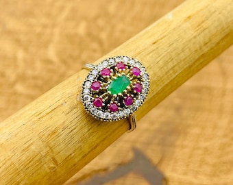 Può includere: Un anello d'argento con una pietra ovale verde circondata da piccole pietre rosa e bianche.