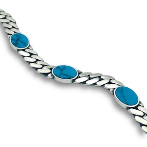 Puede incluir: Una pulsera de plata con un diseño de cadena de eslabones. La pulsera presenta cuatro piedras ovaladas de turquesa engastadas en los eslabones de la cadena. Las piedras de turquesa son de color azul brillante y están engastadas en un bisel de plata.