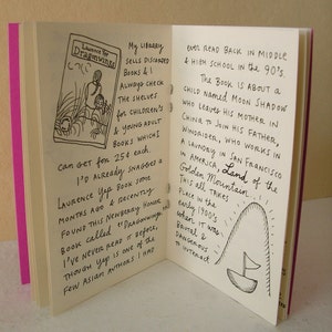 May include: Open book with handwritten text about a child named Moon Shadow who leaves his mother in China to join his father, Windrider, who works in a laundry in San Francisco, California. The text says "Land of the Golden Mountain." The book is illustrated with a small sailboat.