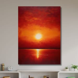 Può includere: Un dipinto che rappresenta un tramonto arancione fiammeggiante su uno specchio d'acqua calmo. Il sole è un cerchio arancione brillante nel cielo, e le nuvole sono un mix di arancione, rosso e giallo. L'acqua è di un rosso profondo, che riflette i colori del cielo.