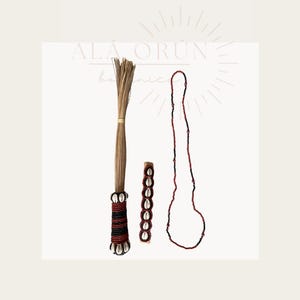 May include: An assortment of handcrafted items, including a beaded necklace, a wristband with cowrie shells, and a bundle of dried grass tied with a yellow band. The items feature red, black, and white accents.