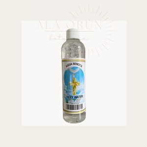 May include: A clear glass bottle with a white cap filled with holy water. The label is white with blue and gold accents and reads "AGUA BENDITA HOLY WATER FOR EXTERNAL USE ONLY 8 FL OZ (236 ml)".