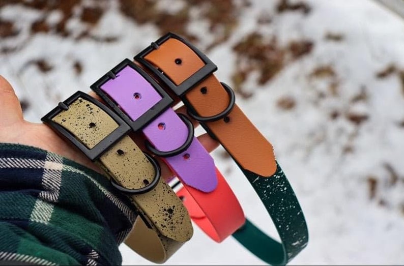May include: Four dog collars in different colors and patterns. The collars are made of a durable material and have a black buckle. The collars are in the following colors: green, orange, purple, and brown.