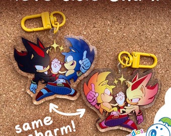 May include: Two reversible acrylic charms featuring Sonic the Hedgehog and Shadow the Hedgehog. One side shows Sonic and Shadow in their standard forms, while the other side displays their super forms. Each charm includes a yellow plastic lobster clasp.