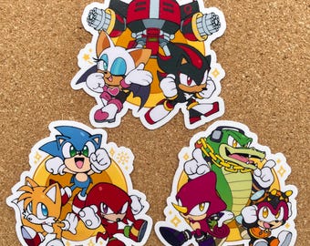 Puede incluir: Un conjunto de nueve pegatinas con personajes de la franquicia de videojuegos Sonic the Hedgehog. Las pegatinas están impresas en papel blanco con un acabado brillante. Los personajes incluyen Sonic, Tails, Knuckles, Amy, Shadow, Rouge, Vector, Espio y Charmy.