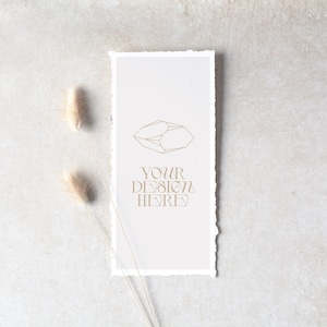 May include: A white card with a geometric design and the text "YOUR DESIGN HERE" in gold lettering. The card is on a light gray background with a dried grass stem.