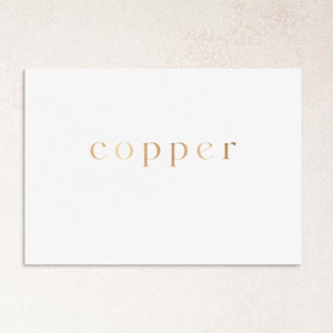 Peut inclure: Une carte blanche avec le mot "copper" imprimé en feuille d'or.