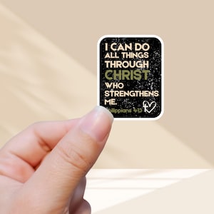 May include: A white sticker with a black border featuring the text "I CAN DO ALL THINGS THROUGH CHRIST WHO STRENGTHENS ME." The word "CHRIST" is in green. The sticker also includes a heart symbol and the text "Philippians 4:13."