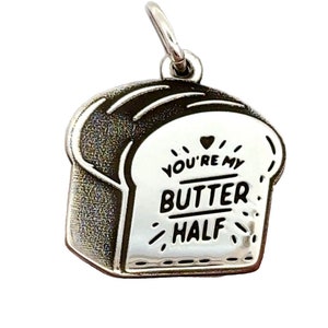 May include: Silver charm shaped like a slice of bread with the text "You're my butter half" and a small heart.