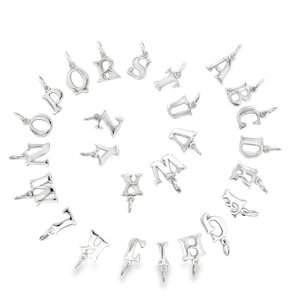 May include: A collection of silver-colored alphabet charms, each with a small loop for attaching to a necklace or bracelet. The letters are in a variety of fonts and sizes, arranged in a circular pattern against a white background.