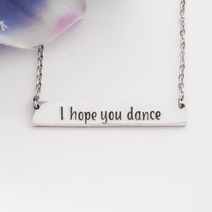 May include: Silver necklace with a bar pendant that reads "I hope you dance".