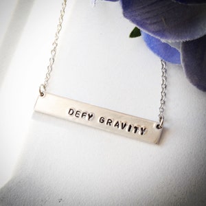 Defy Gravity stamped metal bar necklace