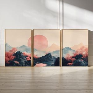 May include: A three-panel print set featuring a stylised landscape with pink and blue hues. The scene depicts a mountain range with a large pink sun in the sky, a river, and pink trees.