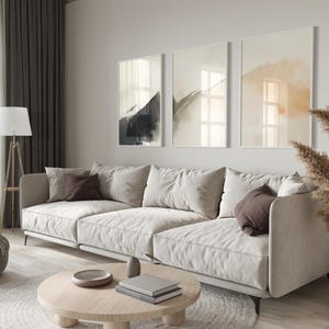 Picture showing a minimalist set of three Japandi-style neutral wall art pieces featuring abstract black and orange brush strokes on a beige background. Available for printing in all standard sizes.