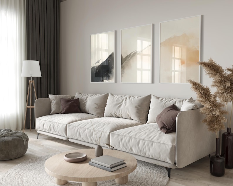 Picture showing a minimalist set of three Japandi-style neutral wall art pieces featuring abstract black and orange brush strokes on a beige background. Available for printing in all standard sizes.