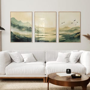 Japandi wall art featuring an olive-green, misty mountain landscape with a serene lake and a traditional Japanese town. This set of three is inspired by Japandi minimalism, this vertical wall art is ready to be printed in all common sizes.