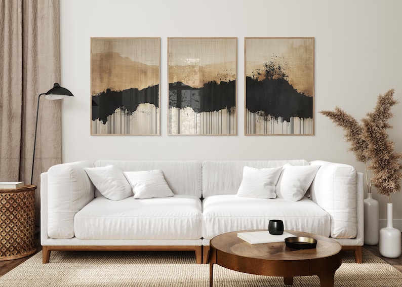 Minimalist abstract triptych featuring earthy beige and black tones with textured brushstrokes and dripping ink effect, evoking Japandi style.