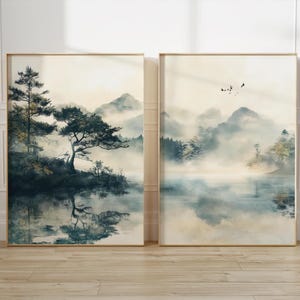 Könnte beinhalten: Zwei gerahmte Aquarellbilder, die eine neblige Berglandschaft mit einem See und Bäumen darstellen. Das linke Bild zeigt einen großen Baum im Vordergrund, während das rechte Bild eine weiter entfernte Ansicht der Berge und des Sees zeigt.