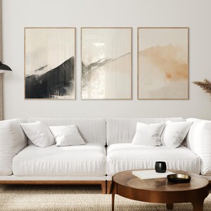 Picture showing a minimalist set of three Japandi-style neutral wall art pieces featuring abstract black and orange brush strokes on a beige background. Available for printing in all standard sizes.
