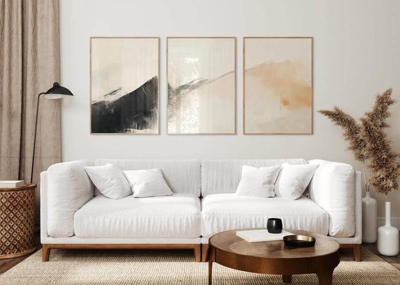 Picture showing a minimalist set of three Japandi-style neutral wall art pieces featuring abstract black and orange brush strokes on a beige background. Available for printing in all standard sizes.