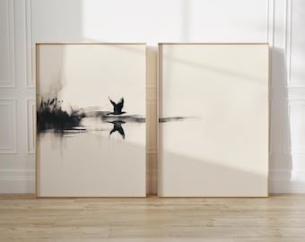 May include: Two framed art prints. The left print features a black and white abstract depiction of a bird in flight over water. The right print is a minimalist design with a cream-colored background. Both are in gold frames.