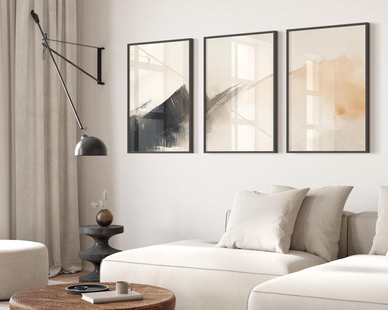 Picture showing a minimalist set of three Japandi-style neutral wall art pieces featuring abstract black and orange brush strokes on a beige background. Available for printing in all standard sizes.