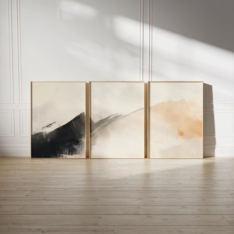 Picture showing a minimalist set of three Japandi-style neutral wall art pieces featuring abstract black and orange brush strokes on a beige background. Available for printing in all standard sizes.