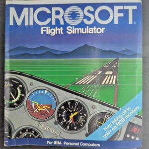 May include: A square box cover for Microsoft Flight Simulator for IBM Personal Computers. The graphic features an airplane cockpit instrument panel in the foreground, a green runway, and blue mountains. Text reads: Now taking off in color on RGB monitors.