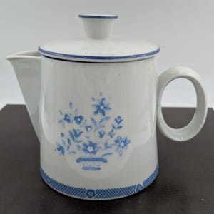 May include: A set of three ceramic mugs with a speckled, matte finish. The mugs are in shades of cream, light gray, and dark gray. Each mug has a simple, minimalist design, perfect for coffee or tea.