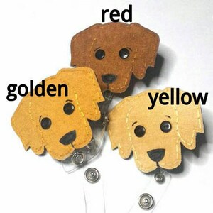 May include: Three felt dog head keychains in red, yellow, and golden colors. The keychains are attached to retractable badge holders.