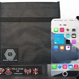 May include: Black Faraday case with a logo and text, next to a smartphone with a Tesla-branded case. The case has a textured surface and a Tesla logo. The phone displays a home screen with app icons.
