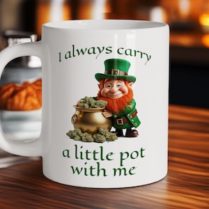 May include: A white ceramic mug with a black handle and the text "But First, Coffee" in a bold, black font. The mug is set against a blurred background, suggesting a cozy setting.