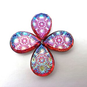 May include: Four iridescent teardrop-shaped glass beads with a geometric pattern. The beads are a mix of red, pink, blue, and purple.