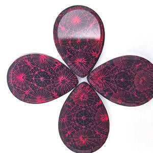 May include: Four teardrop-shaped, black resin guitar picks with a pink geometric pattern.
