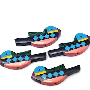 May include: Four colorful bird-shaped pendants with black, green, blue, yellow, pink, and orange geometric patterns. The pendants are made of a smooth, polished material.