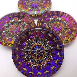 May include: Four iridescent glass buttons with a purple, gold, and blue color scheme. The buttons have a raised, circular design with a starburst pattern.