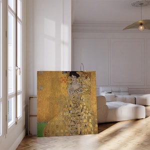Op de afbeelding: Een schilderij van een vrouw in een gouden jurk met een geometrisch patroon. De achtergrond is ook goudkleurig met een geometrisch patroon. De vrouw kijkt naar de kijker.