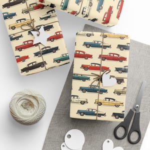May include: Vintage car wrapping paper with a cream background and a repeating pattern of colorful cars. The cars are in shades of red, blue, green, and white.