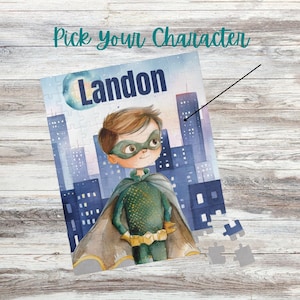 May include: A personalized puzzle featuring a superhero illustration with the name "Landon" in navy blue. The puzzle shows a cityscape backdrop and the text "Pick your Character" in teal.