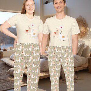 May include: Matching pajama set featuring a cream-colored short-sleeved t-shirt and pajama pants. The shirt has a llama graphic with a heart. The pajama pants have a repeating pattern of llamas, hearts, and speech bubbles on a light green background.