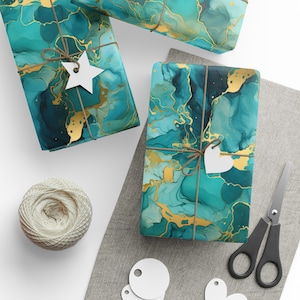 May include: Gift-wrapped presents with teal and gold abstract designs. Each package is tied with twine and a white tag. A ball of twine, scissors, and blank tags are also visible.